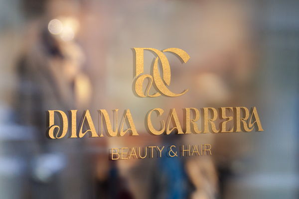 Diana Carrera Beauty & Hair - Goldenes Logo auf einer Glasfassade